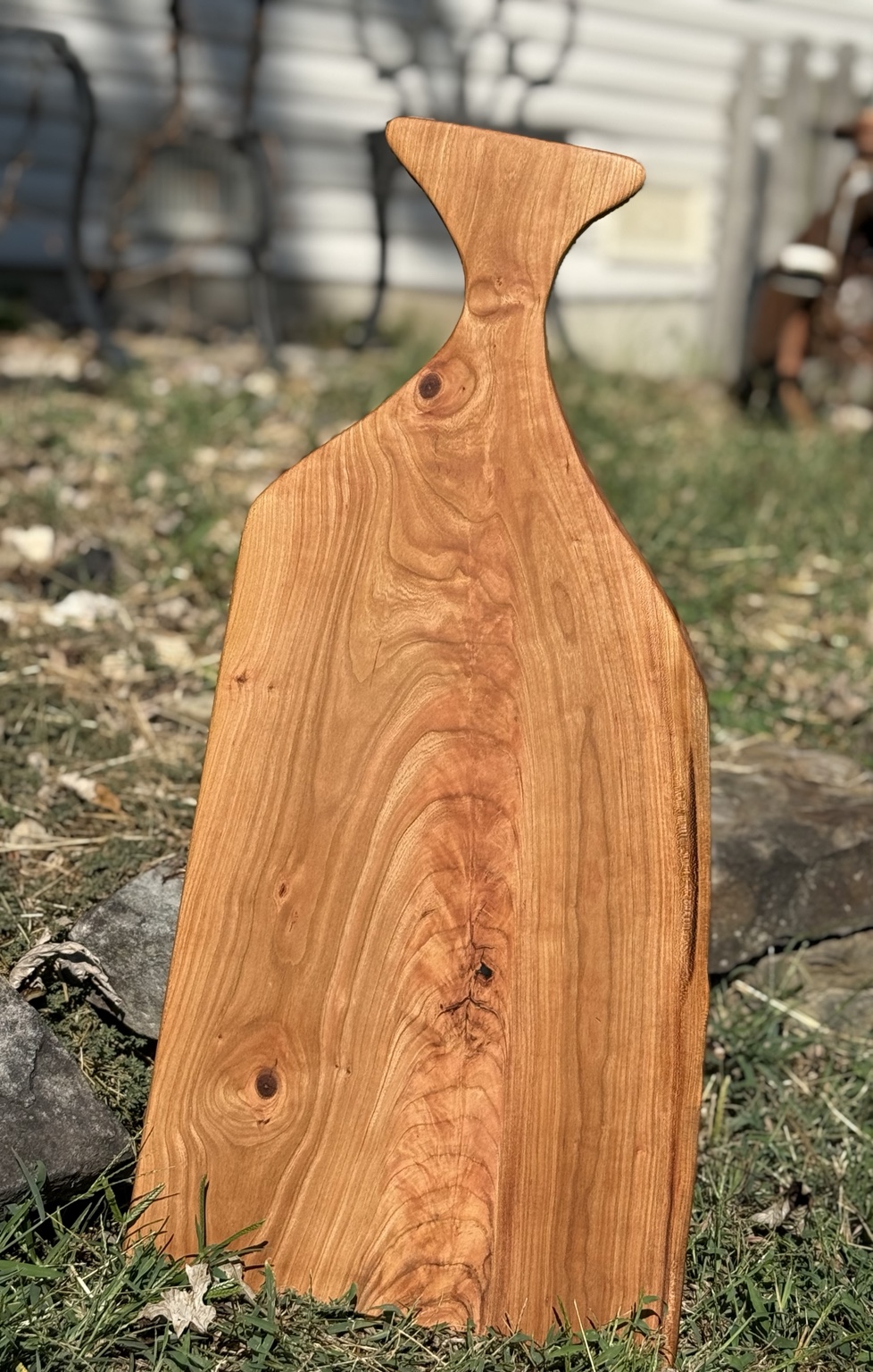 Handcrafted cherry charcuterie board with distinctive fan-shaped grain and sculpted handle